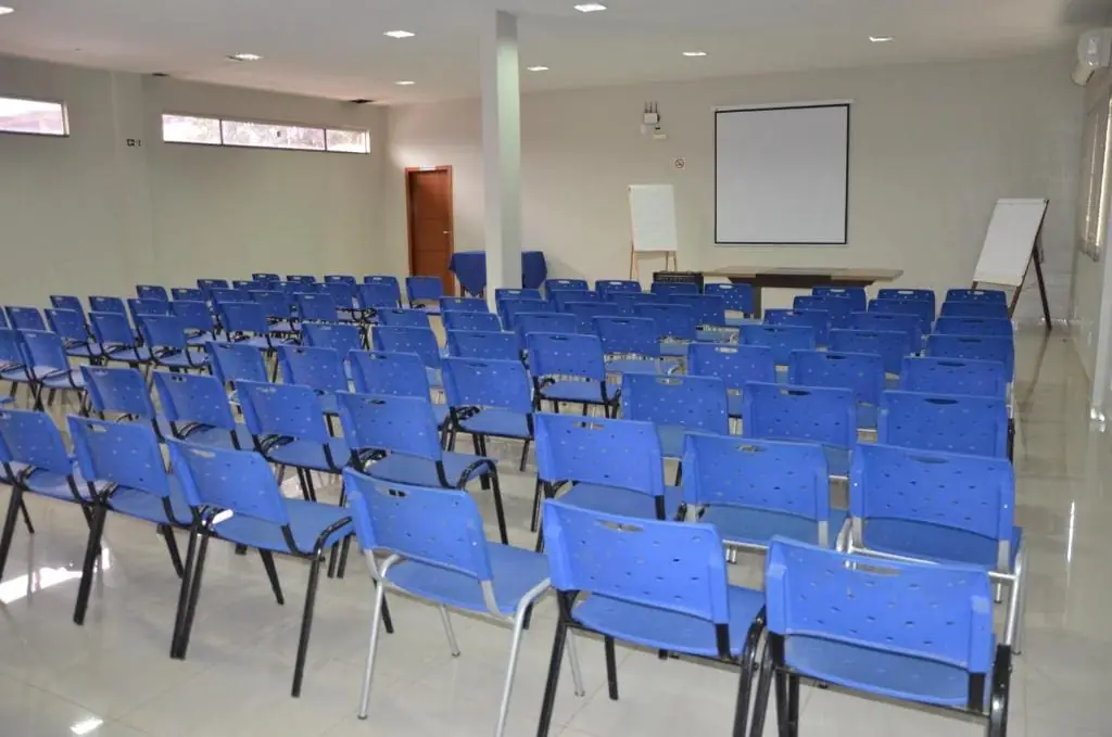 Auditório com cadeiras voltadas para a tela de projeção