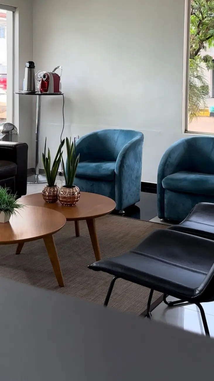 Lounge de espera do hotel com poltronas azuis e mesa de centro