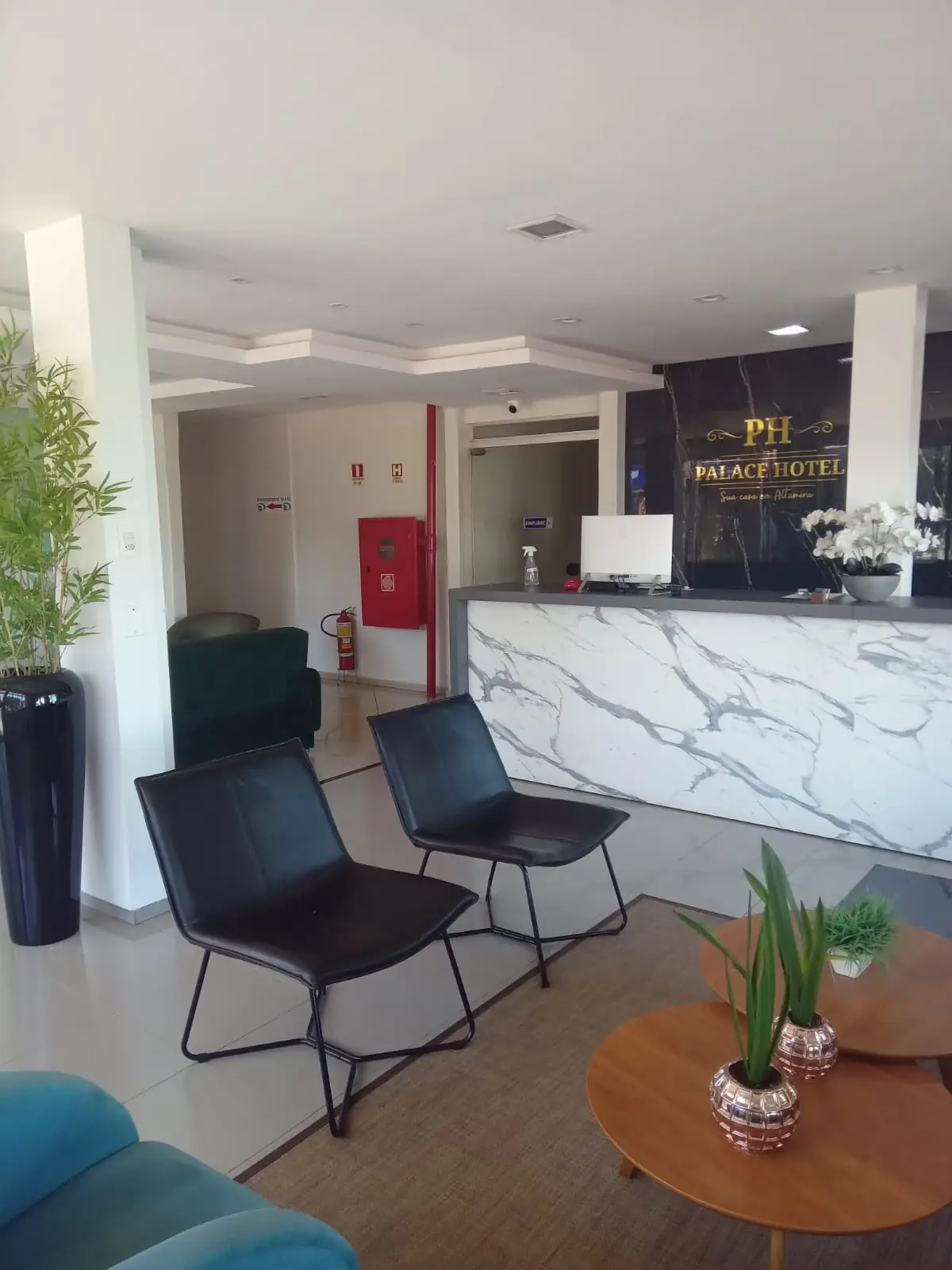 Recepção do Palace Hotel Altamira, com balcão em mármore e poltronas